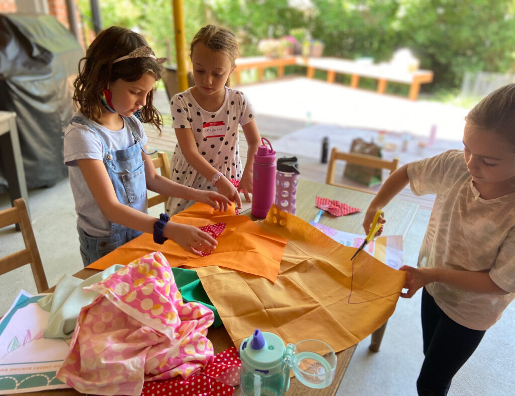 The young kids working on their first sewing project.