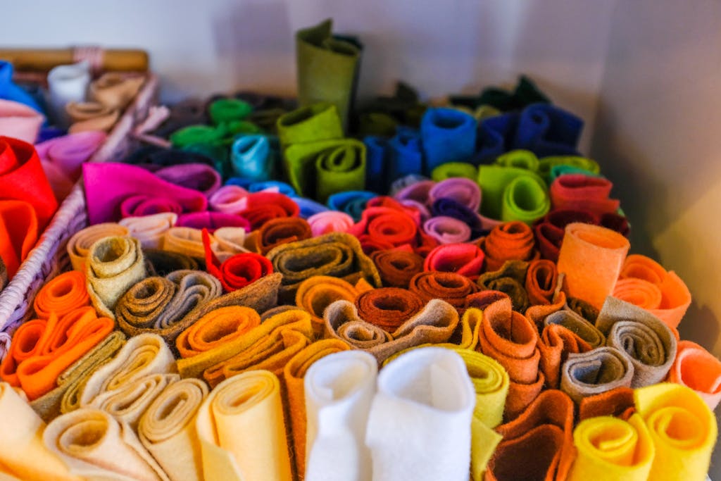 A colorful assortment of rolled felt fabric pieces in various hues, perfect for arts and crafts.